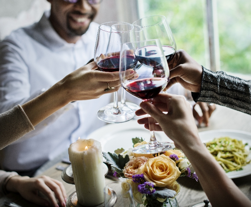 People Clinging Wine Glasses Together in Restaurant